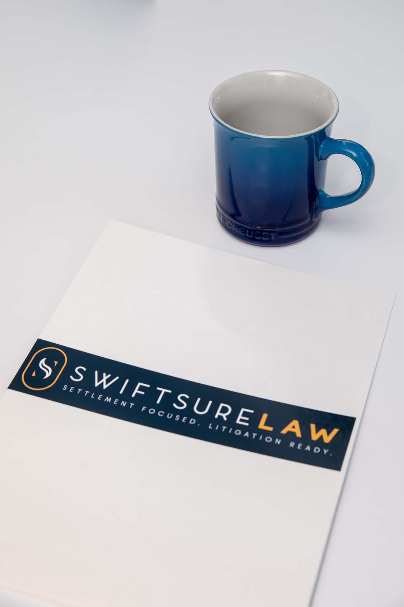 Picture of a document that has swiftsure law logo and blue cup on top